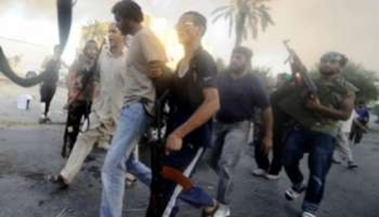 Des rebelles libyens arrêtent un combattant pro-Kaddafi, le 25 août 2011, au sud de Tripoli. © AFP