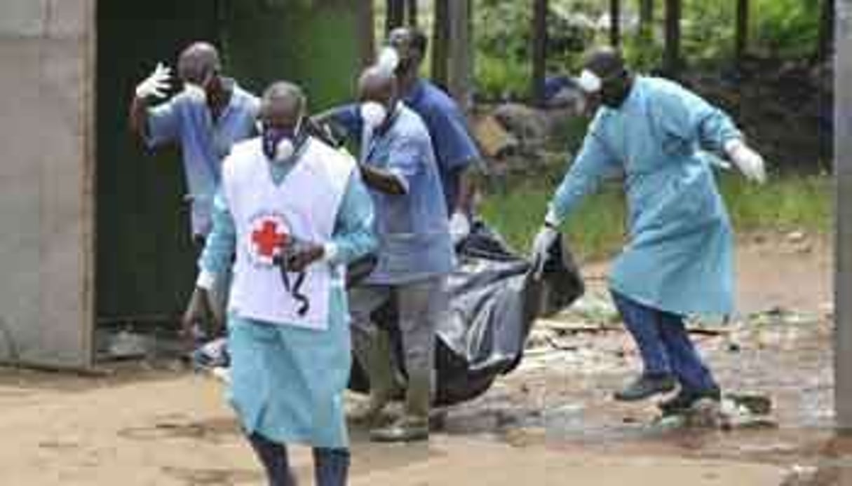 Des membres de la Croix Rouge ivoirienne emmènent un cadavre le 4 mai 2011 à Abidjan. © AFP