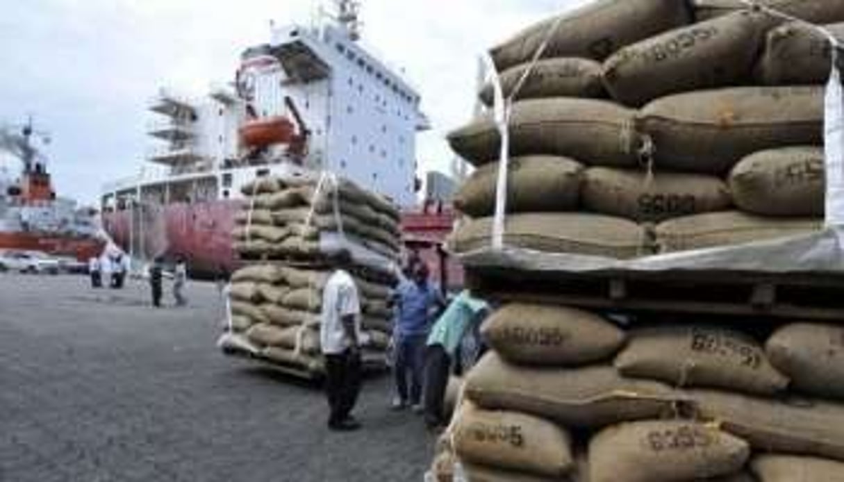 Hommes chargeant un bateau de sa cargaison de sacs de cacao le 10 mai 2011 dans le port d’Abidjan. © AFP