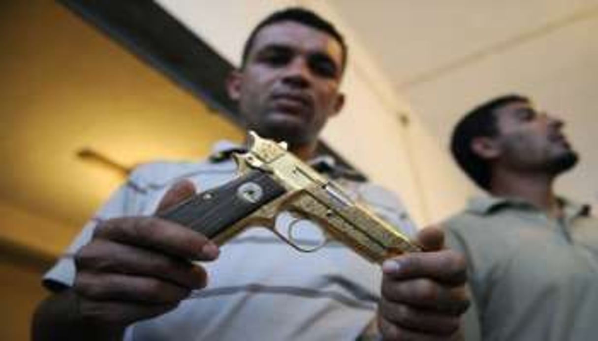 Un combattant du CNT libyen montre l’arme plaquée or de Mouammar Kaddafi, après sa capture le 21 o © AFP
