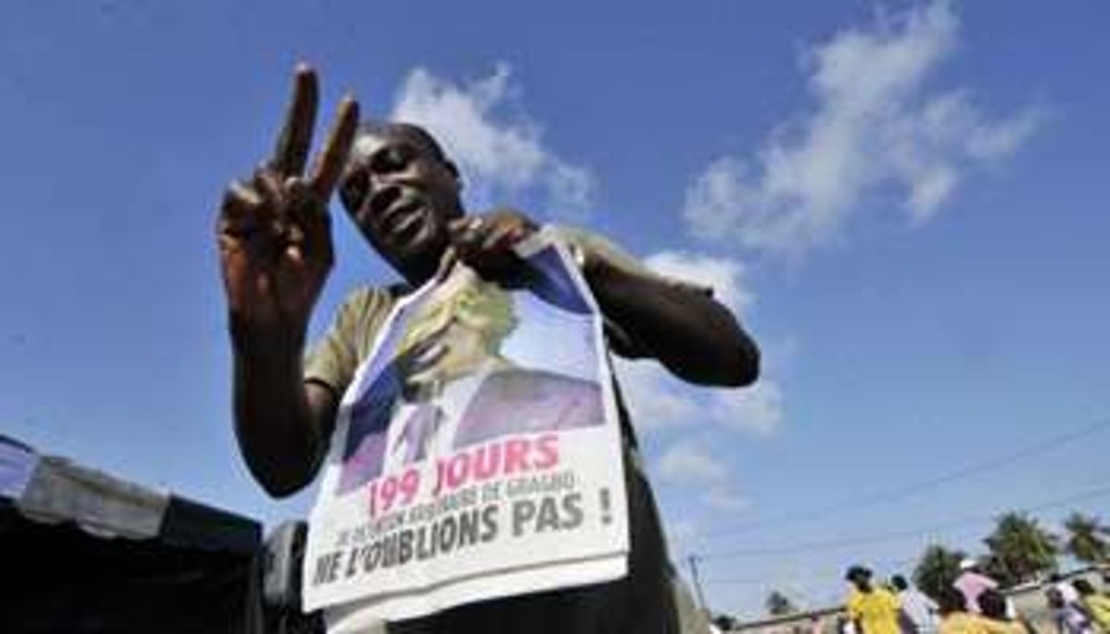 Un partisan du Front populaire ivoirien avec un journal à l’effigie de Laurent Gbagbo. © AFP