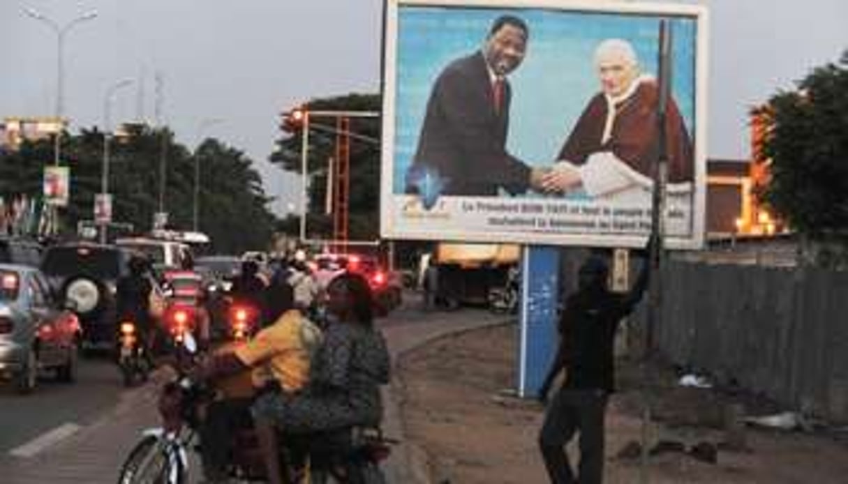 À Cotonou, une des affiches représentant le pape et le président Boni Yayi. © AFP