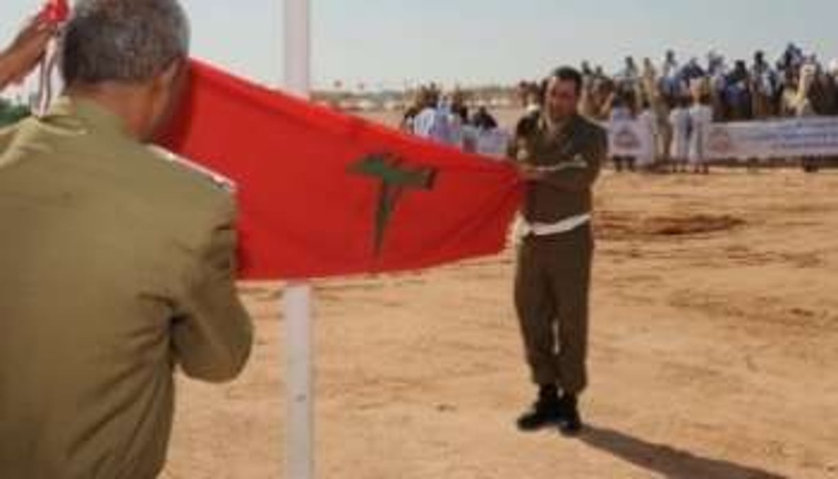 Des soldats marocains hissant le drapeau du royaume à Laâyoune, au Sahara. © AFP/Abdelhak Senna