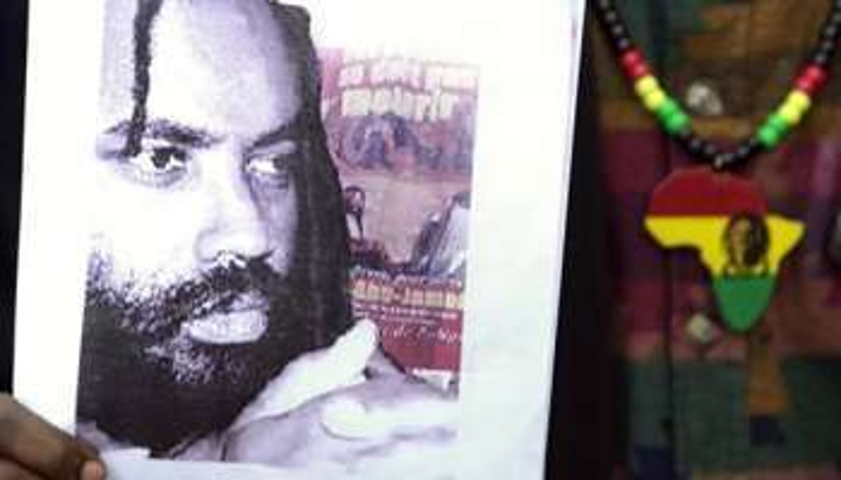 Une photographie de Mumia Abu-Jamal exhibée lors d’une manifestation, en 2001 à Paris. © AFP