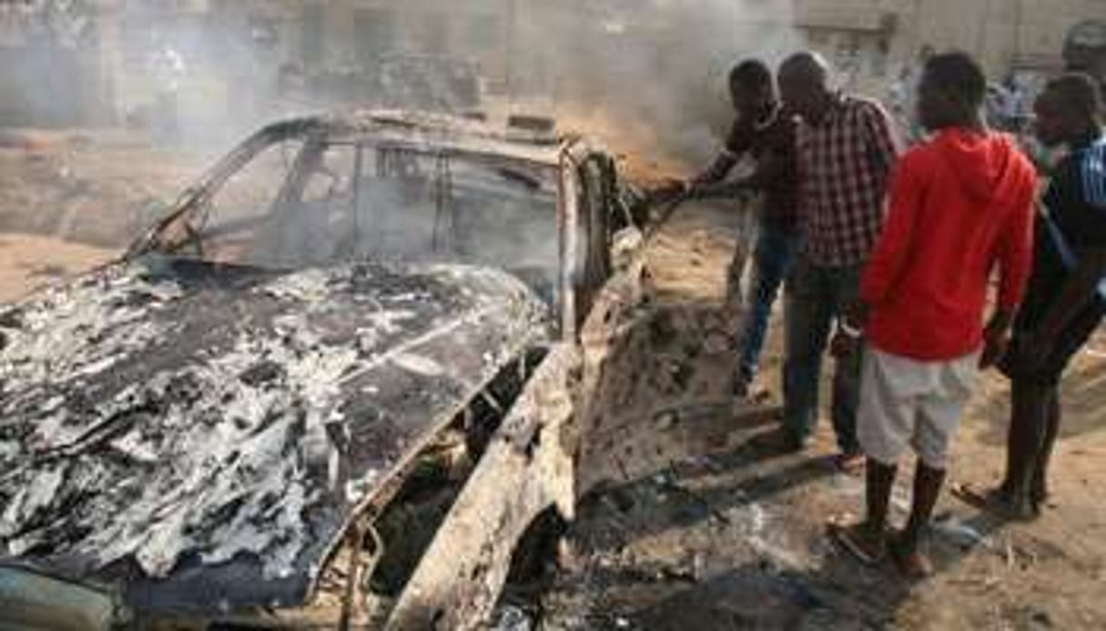 La carcasse d’une voiture détruite par un attentat devant l’église Sainte Thérèse près d’Abuja. © AFP