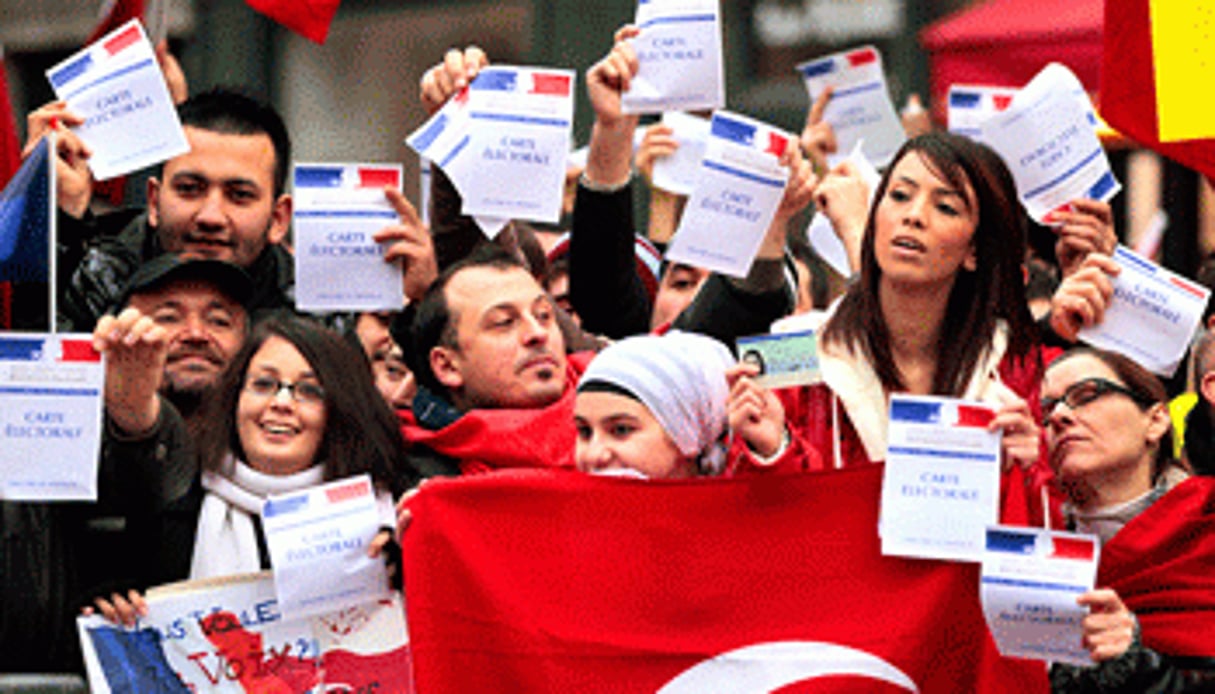 Les Turcs de France brandissent leur carte d’électeur, devant le Palais-Bourbon, à Paris. © Charles Platiau/Reuters