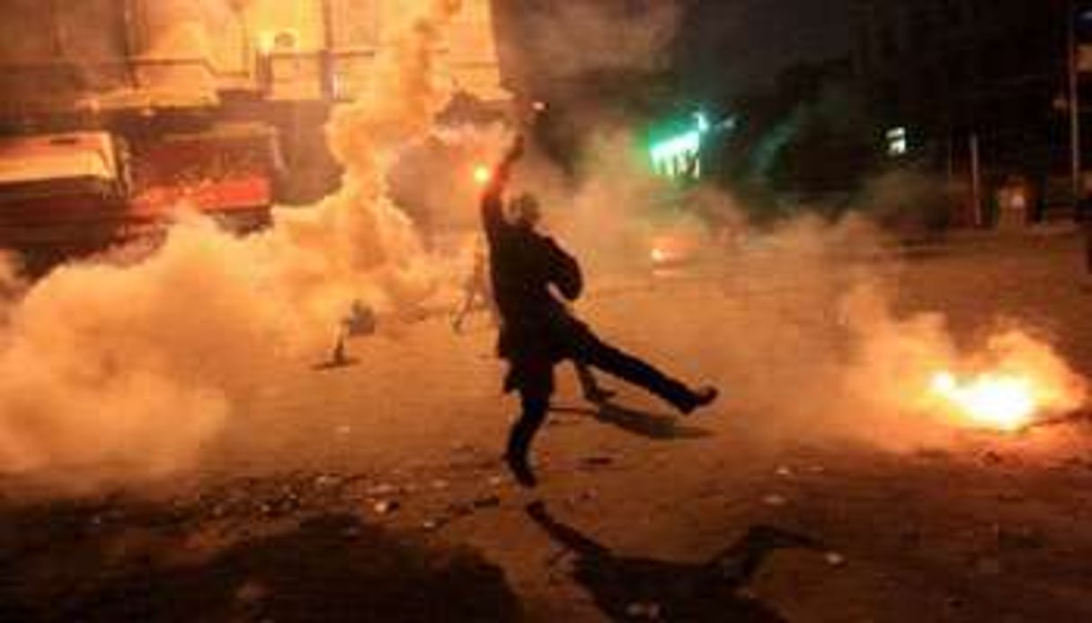 Un manifestant lance une grenade lacrymogène contre les forces de l’ordre égyptiennes. © AFP