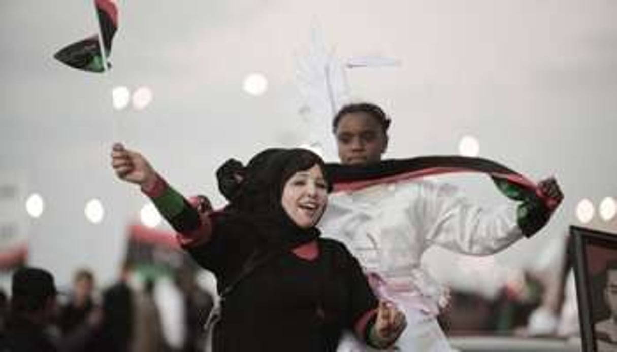 De jeunes libyennes agitent le nouveau drapeau de leur pays à Benghazi le 16 février 2012. © AFP