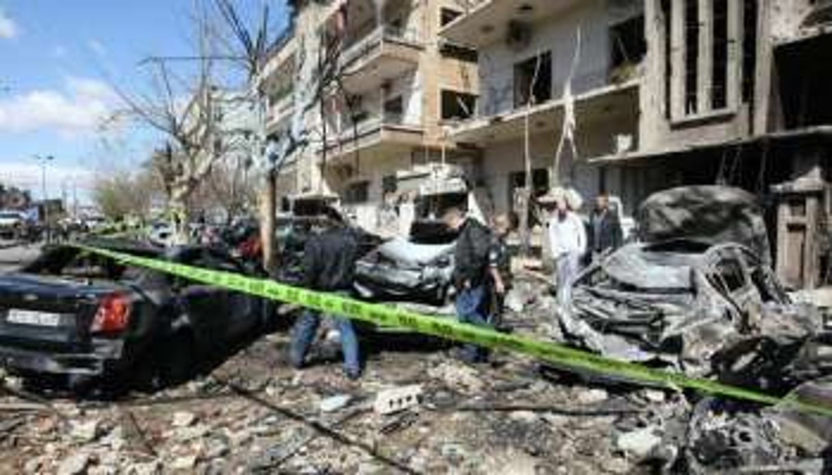 Des véhicules détruits après des attentats commis le 17 mars 2012 à Damas. © AFP