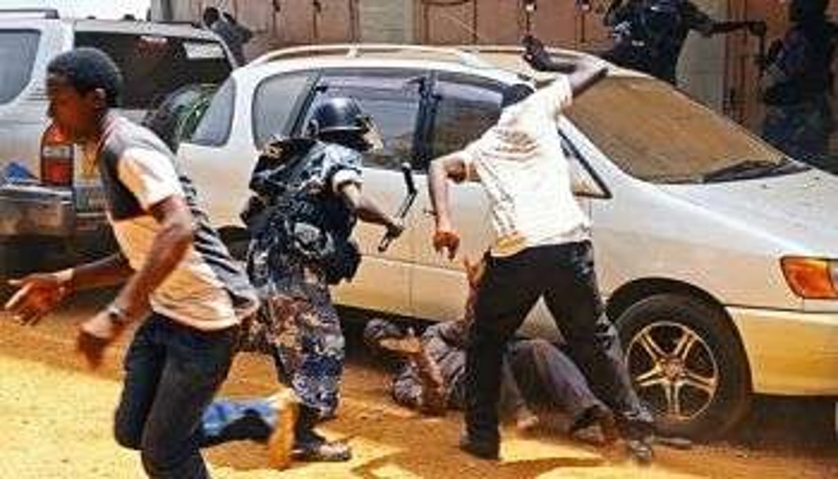 La police frappe un homme lors d’une manifestation de l’opposition à Kampala le 21 mars 2012. © AFP