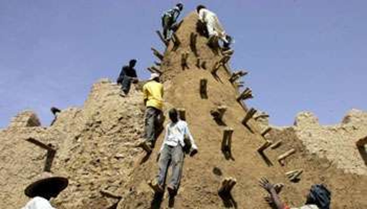 Des habitants de Tombouctou restaurent la grande mosquée construite en 1327 par l’empereur Kancan. © AFP