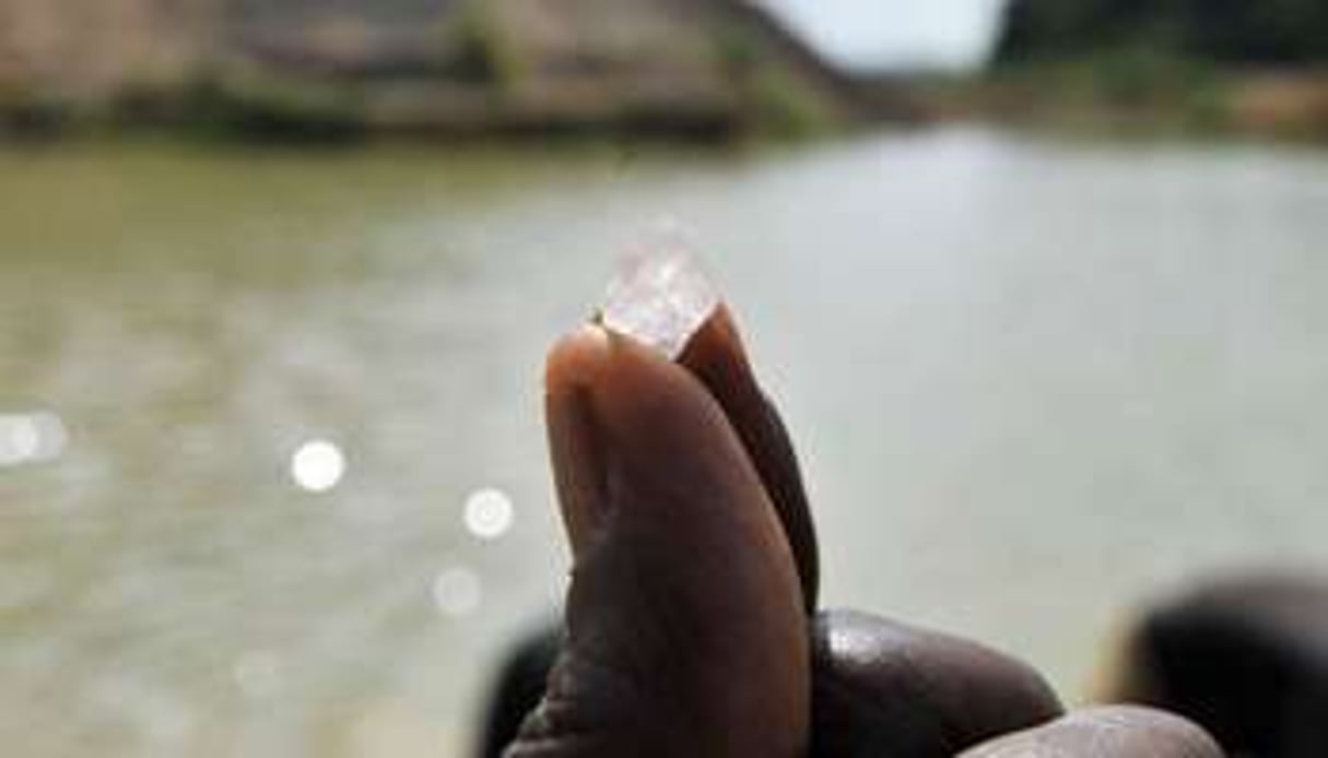 Un chercheur de diamant montre une pierre trouvée à Koidu, le 28 avril 2012. © AFP