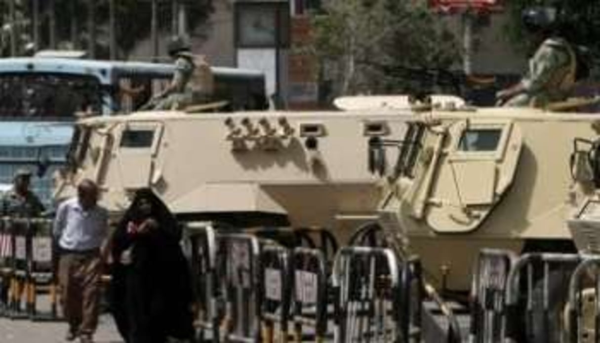 Des Égyptiens passent devant des chars de l’armée dans une rue du Caire, le 22 mai 2012. © Mahmud Hams/AFP