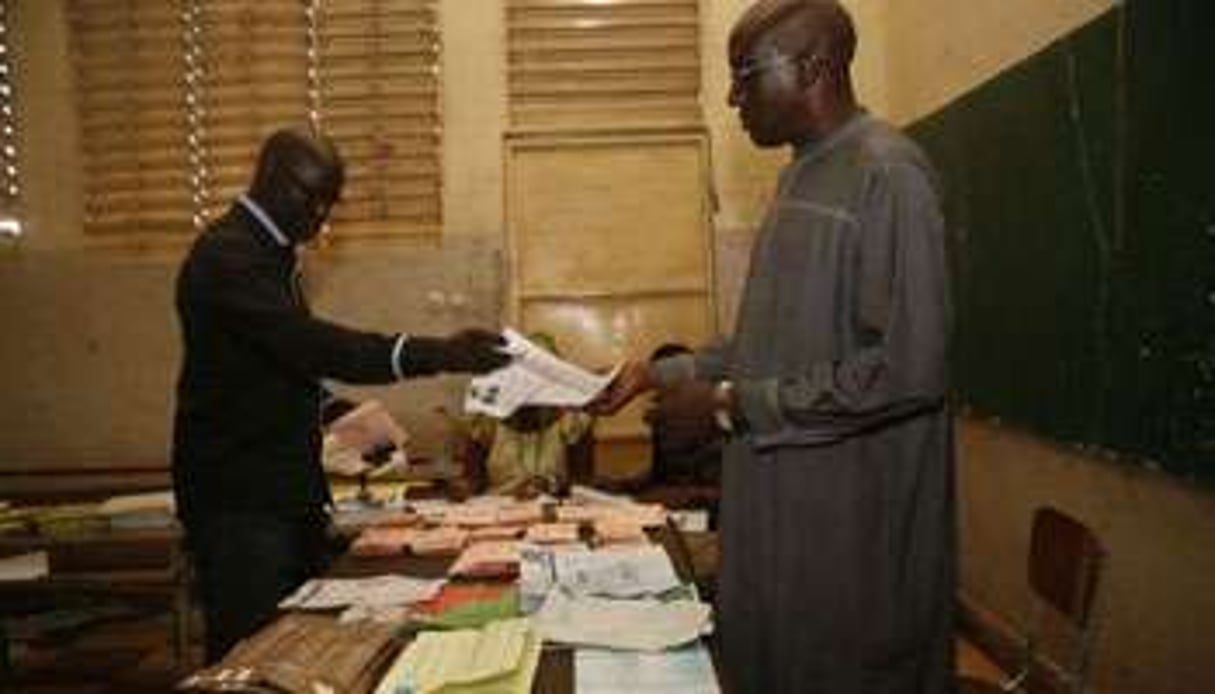 Des scrutateurs comptent les bulletins de vote à Dakar. © AFP