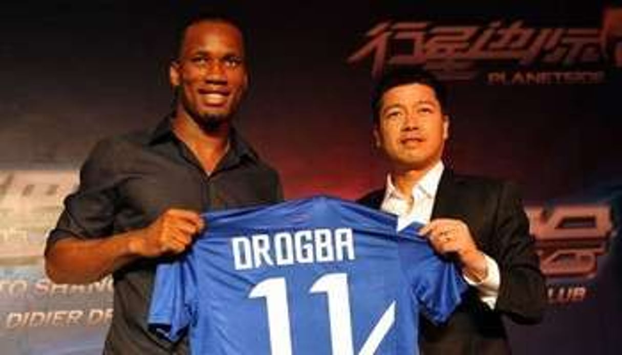Didier Drogba (g) et le propriétaire du club de foot Shangai Shenhua, Zhu Jun, le 14 juillet 2012. © AFP