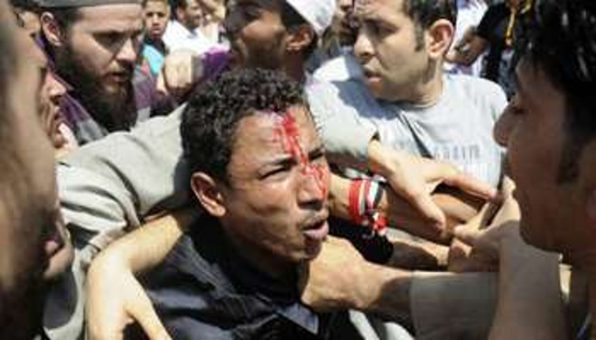 Des Égyptiens soutenant Mohamed Morsi se battent avec des opposants, sur la place Tahrir au Caire. © AFP