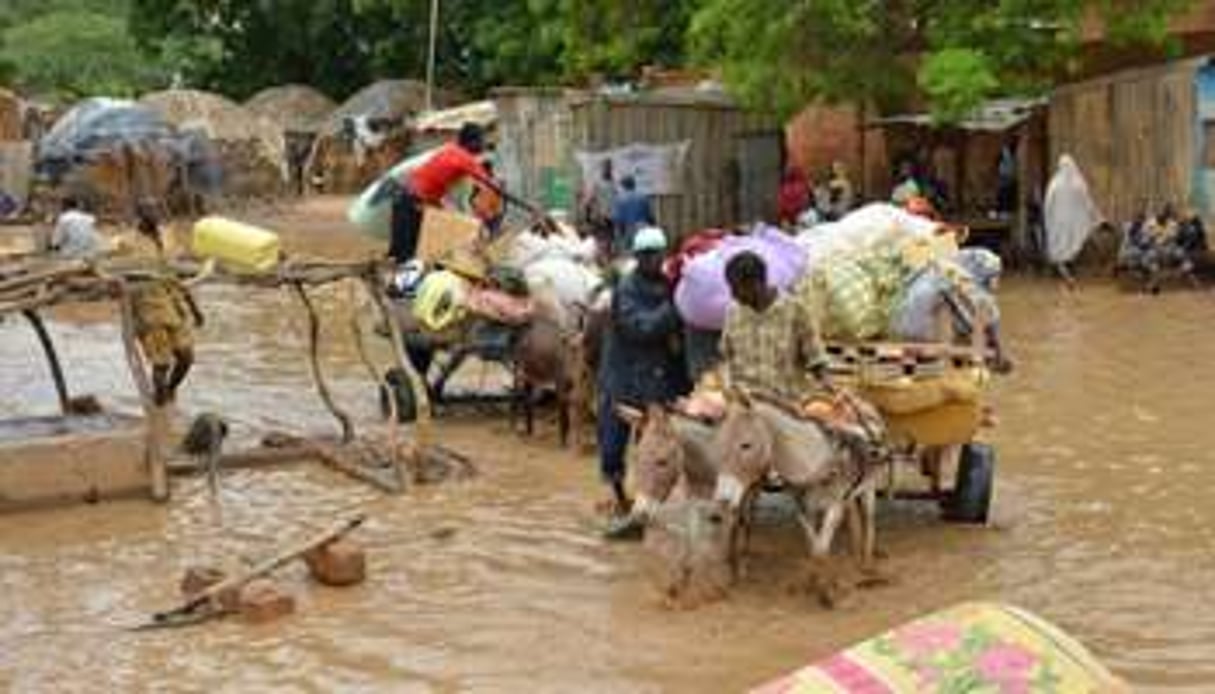 Des habitants de Niamey évacuent leurs maisons, le 19 août 2012 après des inondations. © AFP