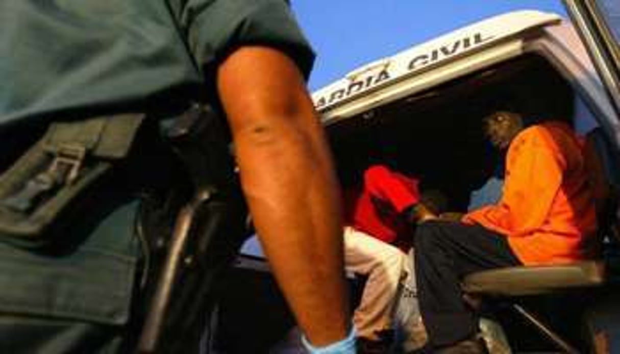 Des membres de la Garde civile espagnole emmènent des migrants dans un fourgon, le 5 août 2005. © AFP