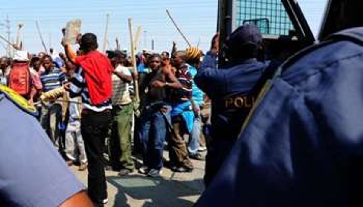 Policiers et mineurs grévistes d’Amplats se font face à Rustenburg, le 12 septembre. © AFP/Archives – Alexander Joe