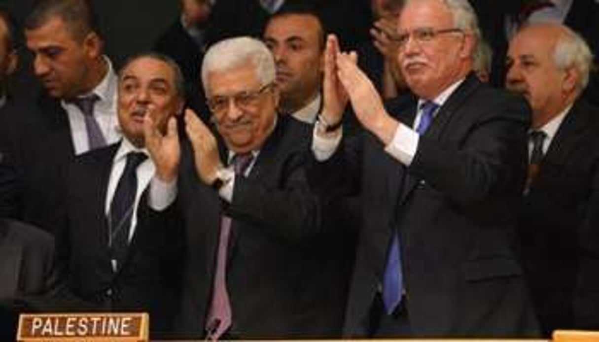 Mahmoud Abbas (au c.) et la délégation palestinienne applaudissent le vote de la résolution. © AFP