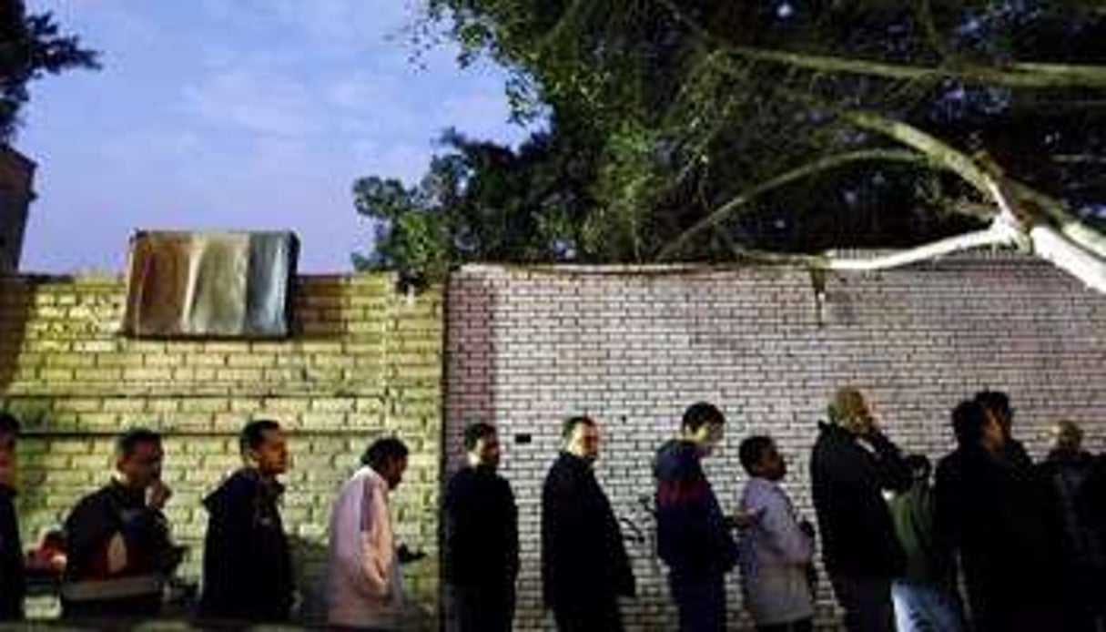 Des Egyptiens font la queue devant un bureau de vote du Caire, le 15 décembre 2012. © AFP