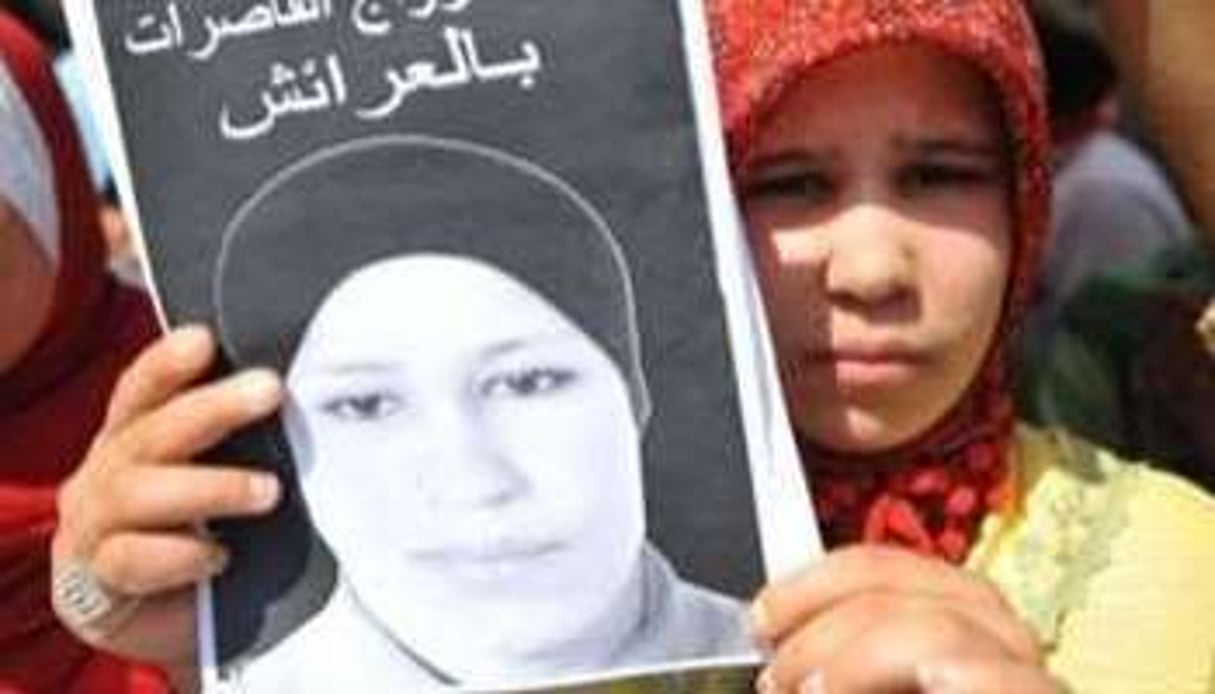 Hamida Al Filali brandit le portrait de sa soeur lors d’une manifestation l’an dernier. © AFP