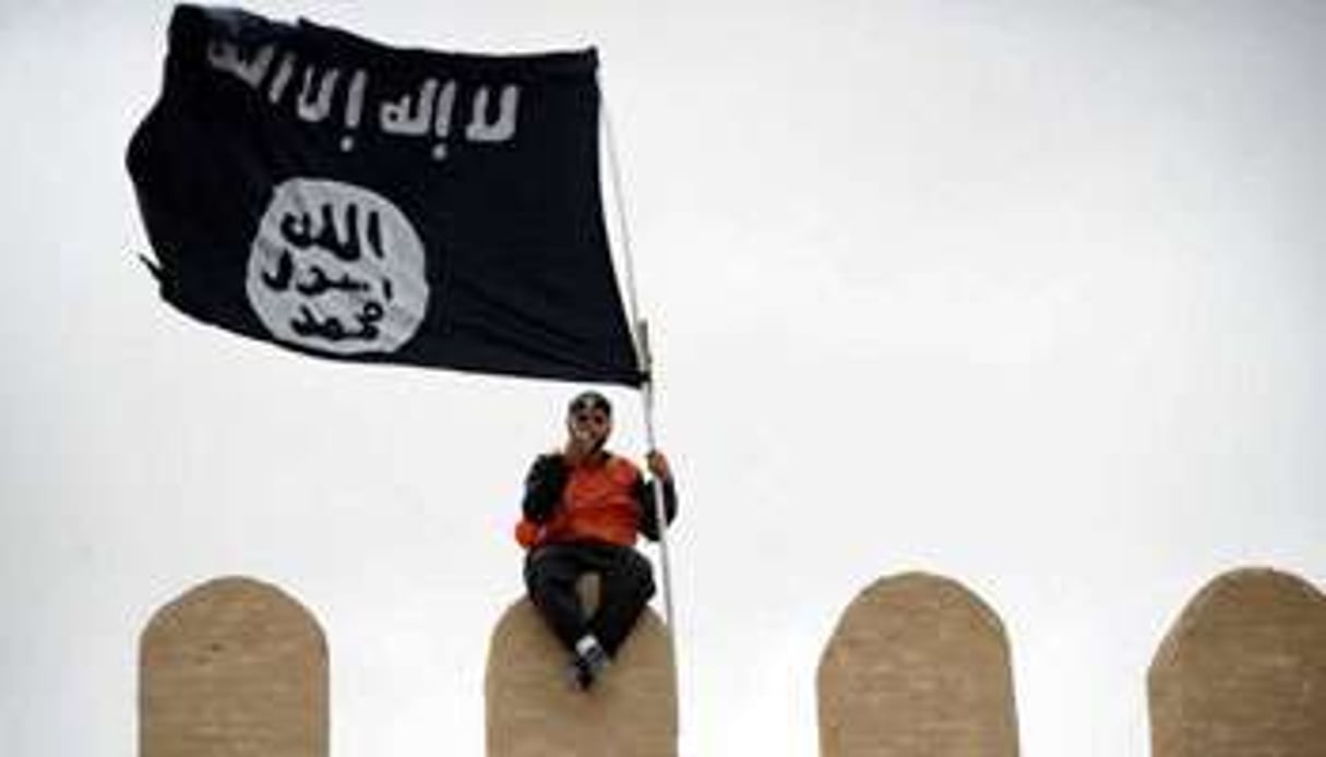 Un tunisien brandissant le drapeau noir salafiste. © AFP