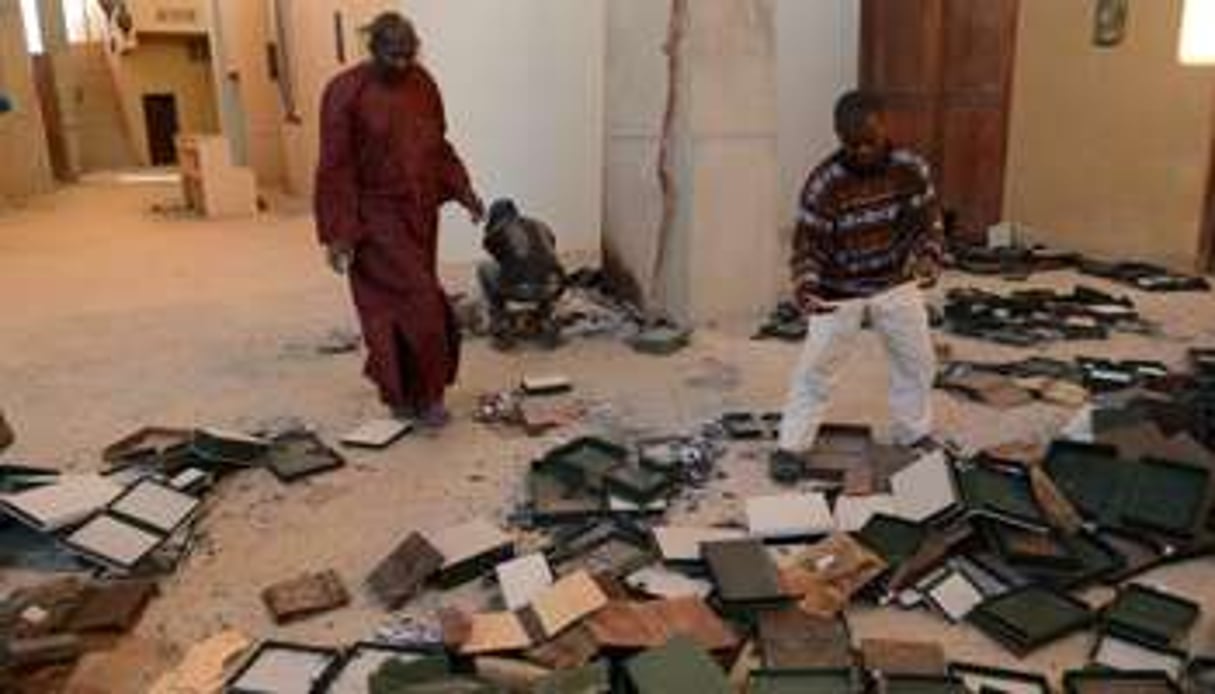 Des hommes au milieu de manuscrits brûlés, à l’Institut Ahmed Baba de Tombouctou, le 29 janvier. © AFP