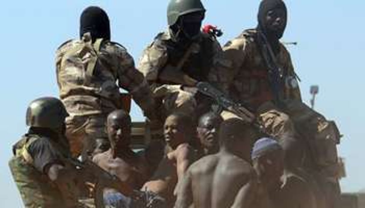 Des soldats maliens transportent des hommes suspectés d’être des islamistes armés. © AFP