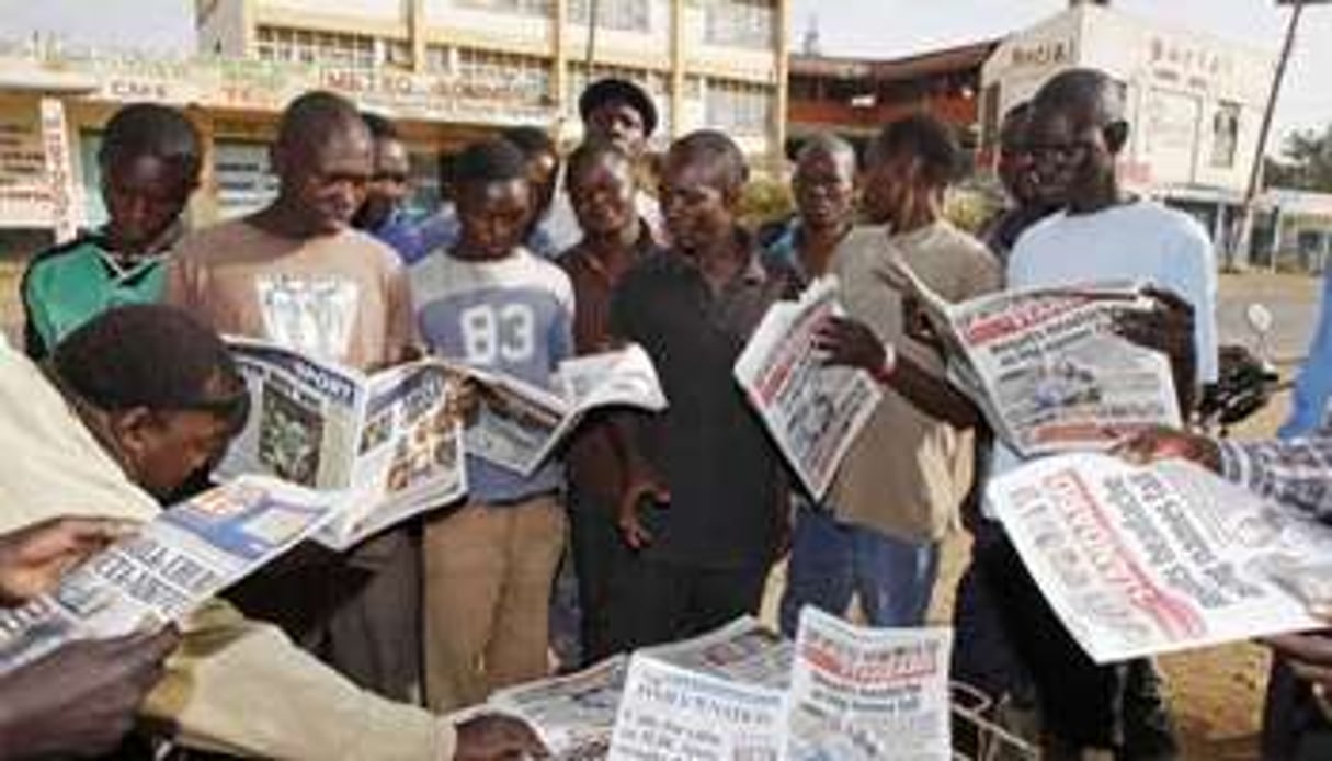 Des Kenyans s’informent des résultats le 6 mars 2013 à Kisumu. © Till Muellenmeister/AFP