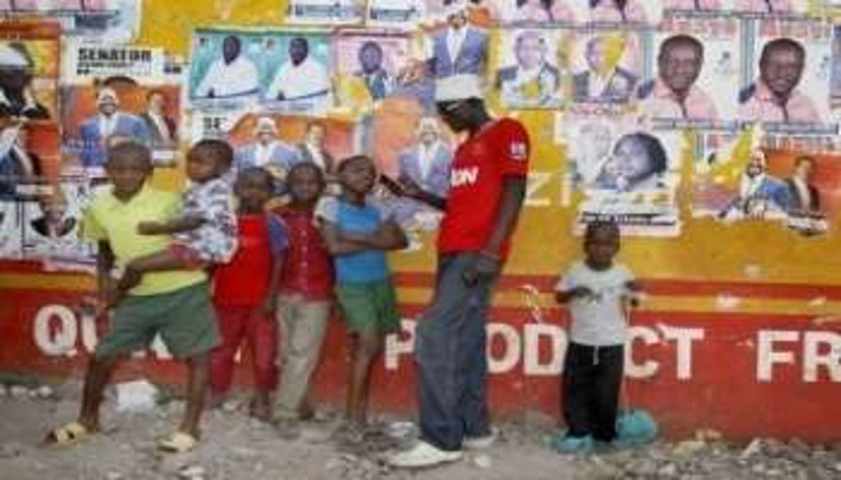 Des Kényans devant des affiches électorales à Kisumu le 6 mars 2013 © AFP