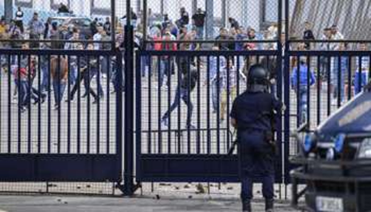 Des Marocains jettent des pierres contre l’enclave espagnole de Melilla, en octobre 2012. © AFP