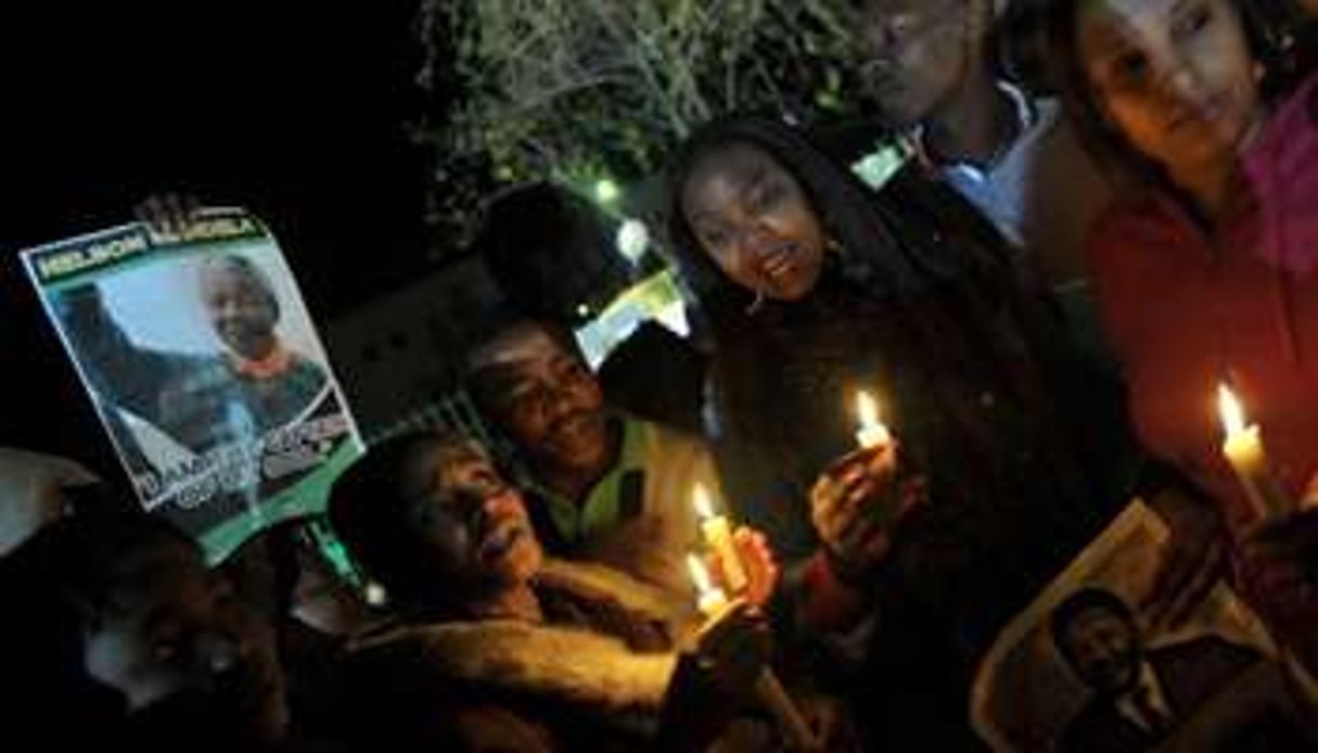 Des Sud-Africains en prière le 27 juin 2013 devant la clinique où est hospitalisé Nelson Mandela. © AFP