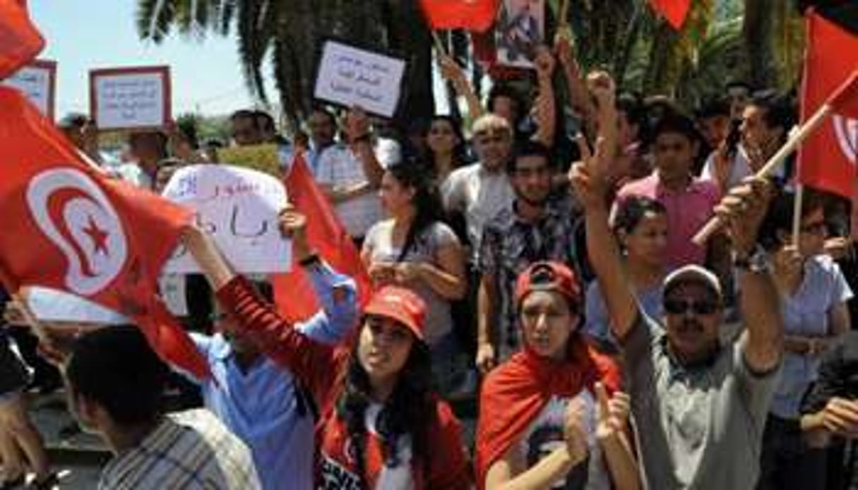 Des manifestants crient des slogans contre Ennahdha devant l’Assemblée tunisienne. © AFP