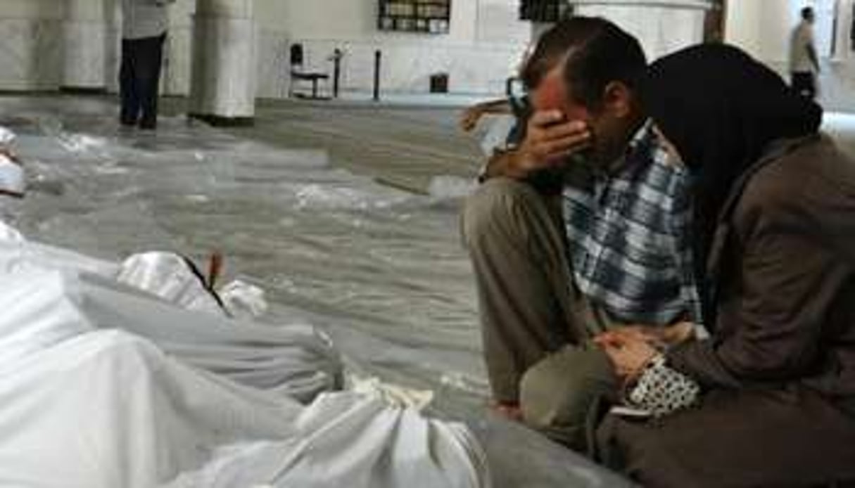 Un couple pleurant face aux cadavres de proches. © AFP