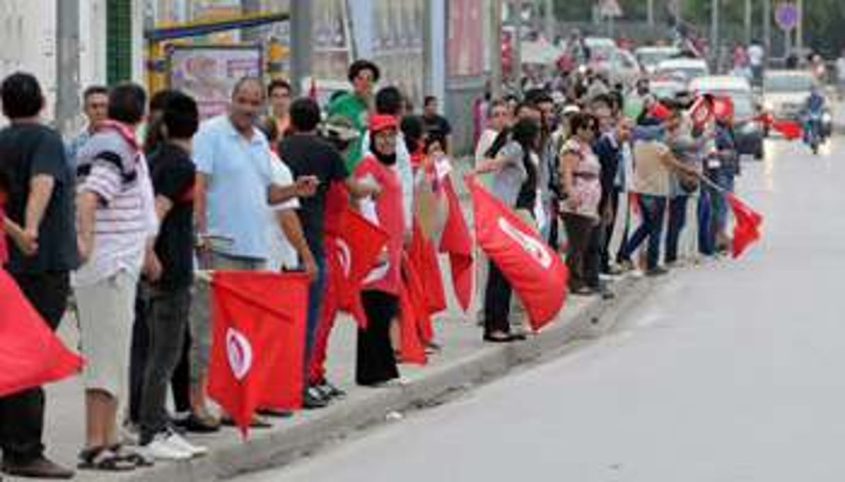 Une chaîne humaine formée pour réclamer la démission du gouvernement, le 31 août 2013 à Tunis. © AFP