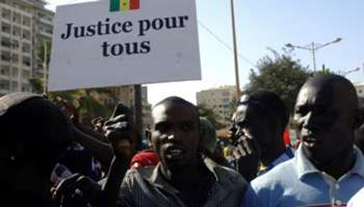 Un Sénégalais tenant une pancarte lors des manifestations le 19 mars 2011. © Erick Christian Ahounou/AFP