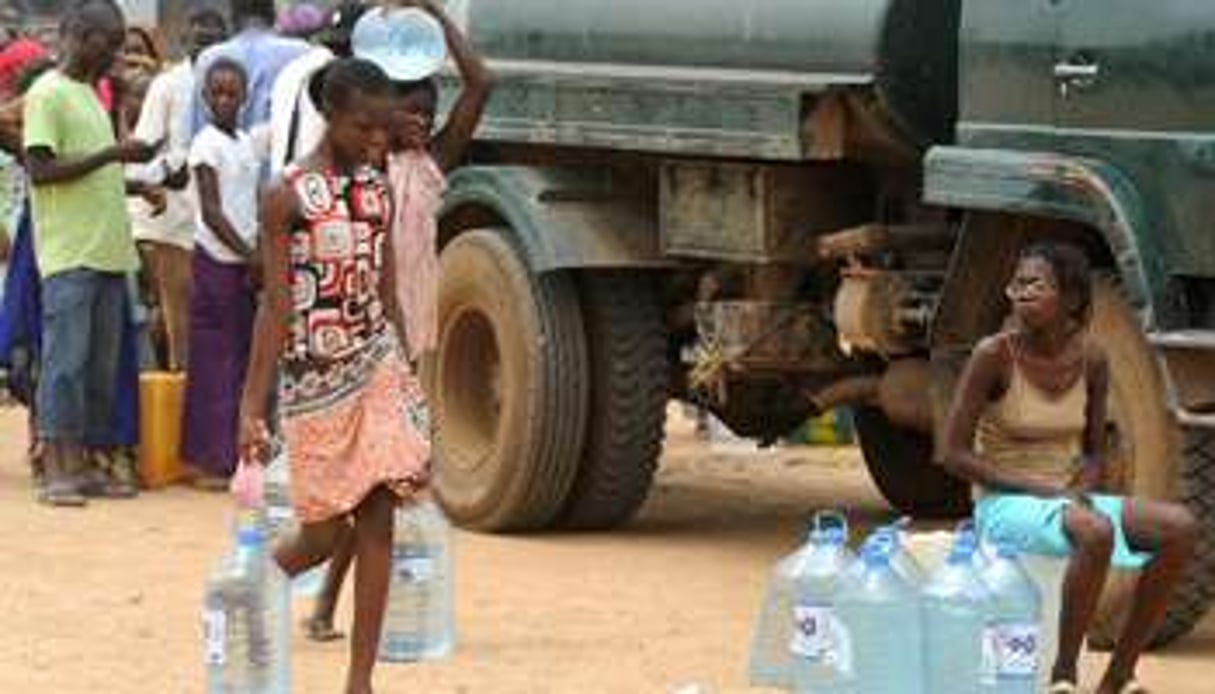 Des personnes cherchent de l’eau à un point de distribution, à Dakar le 26 septembre 2013. © AFP
