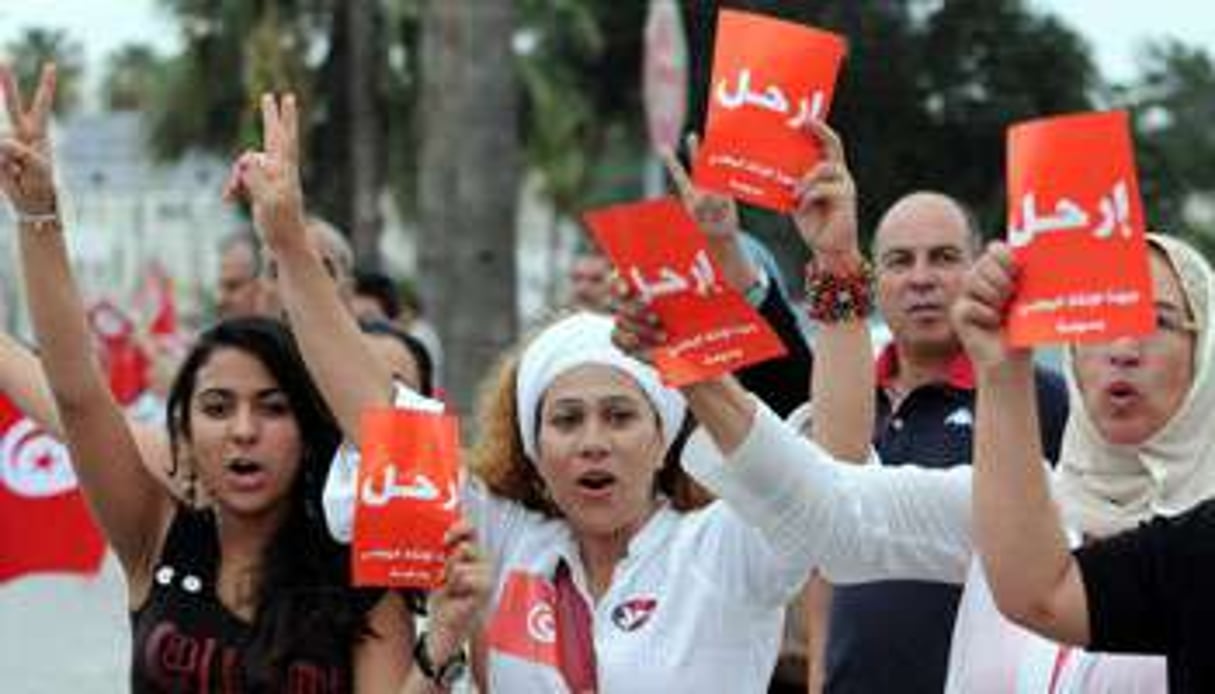 Des manifestants tiennent des prospectus où il est écrit « Partez », à destination du gouvernement. © SALAH HABIBI / AFP