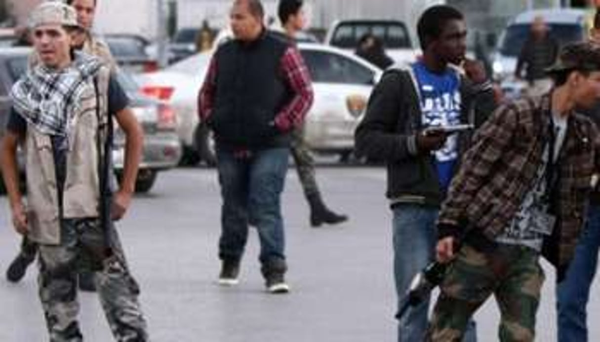 Des jeunes miliciens dans les rues de Tripoli en avril 2012. © AFP