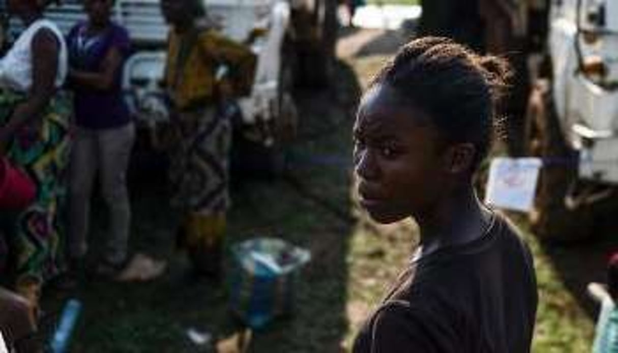 Des personnes attendent l’aide alimentaire de l’ONU près d’un camp de déplacés à Bangui. © AFP