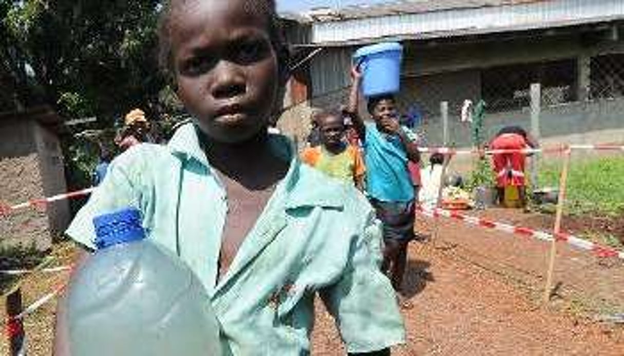 Une jeune fille porte une bouteille d’eau dans un centre catholique de Bangui, le 14 décembre 2013. © AFP