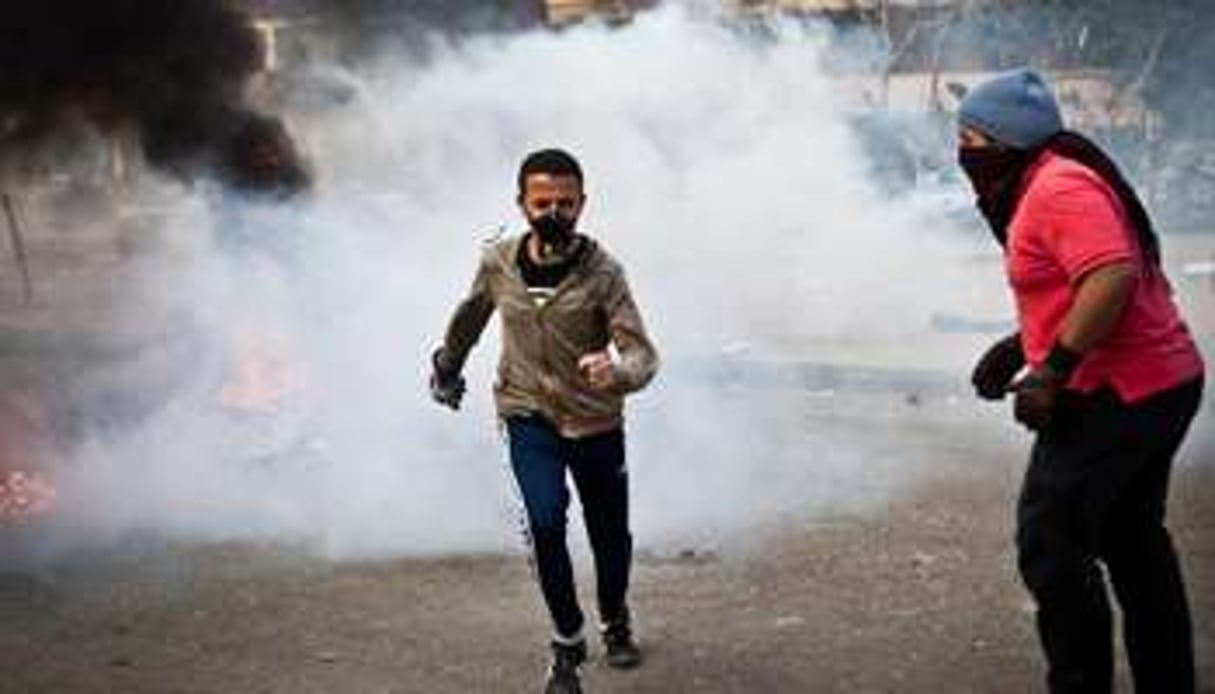 Des partisans du président égyptien déchu Mohamed Morsi fuient les gaz lacrymogènes. © AFP