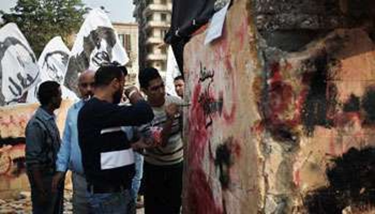 Des Egyptiens peignent un graffiti sur un monument dédié aux victimes des soulèvements © AFP