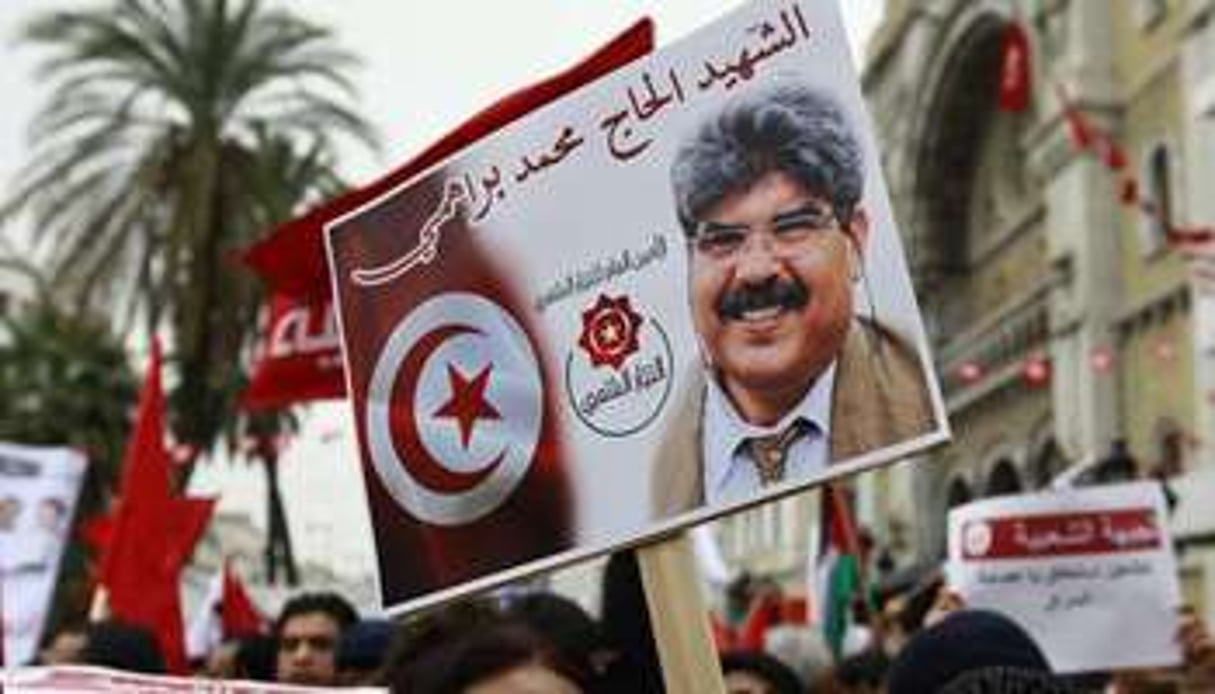 Un manifestant porte un portrait de Mohamed Brahmi, le 14 janvier 2014 à Tunis. © Reuters