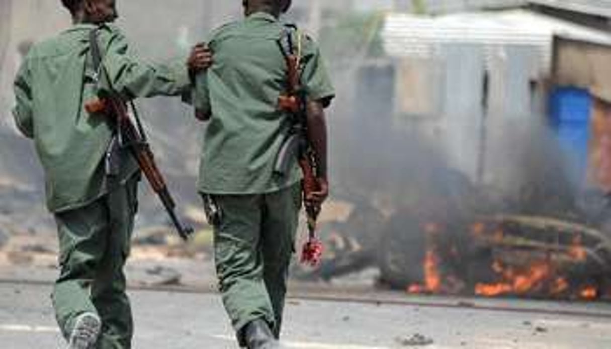 Deux soldats somaliens à Mogadiscio après un attentat à la voiture piégée, le 13 février. © AFP