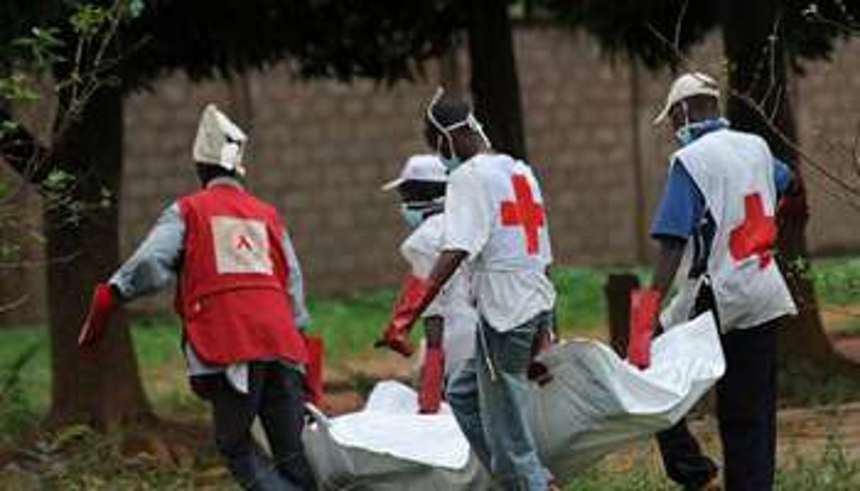 Des membres de la Croix-Rouge transportent un corps après des affrontements meurtriers à Bangui. © AFP