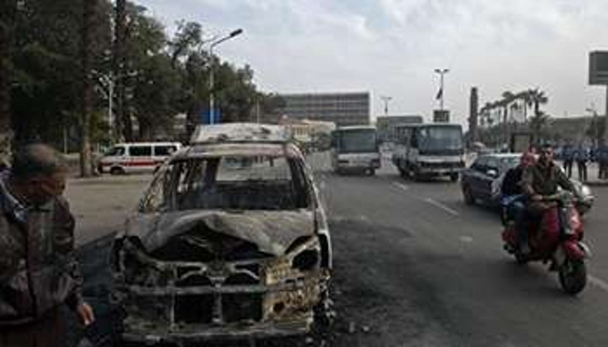 La carcasse calcinée d’un véhicule incendié lors d’incidents le 9 mars 2014 au Caire. © AFP