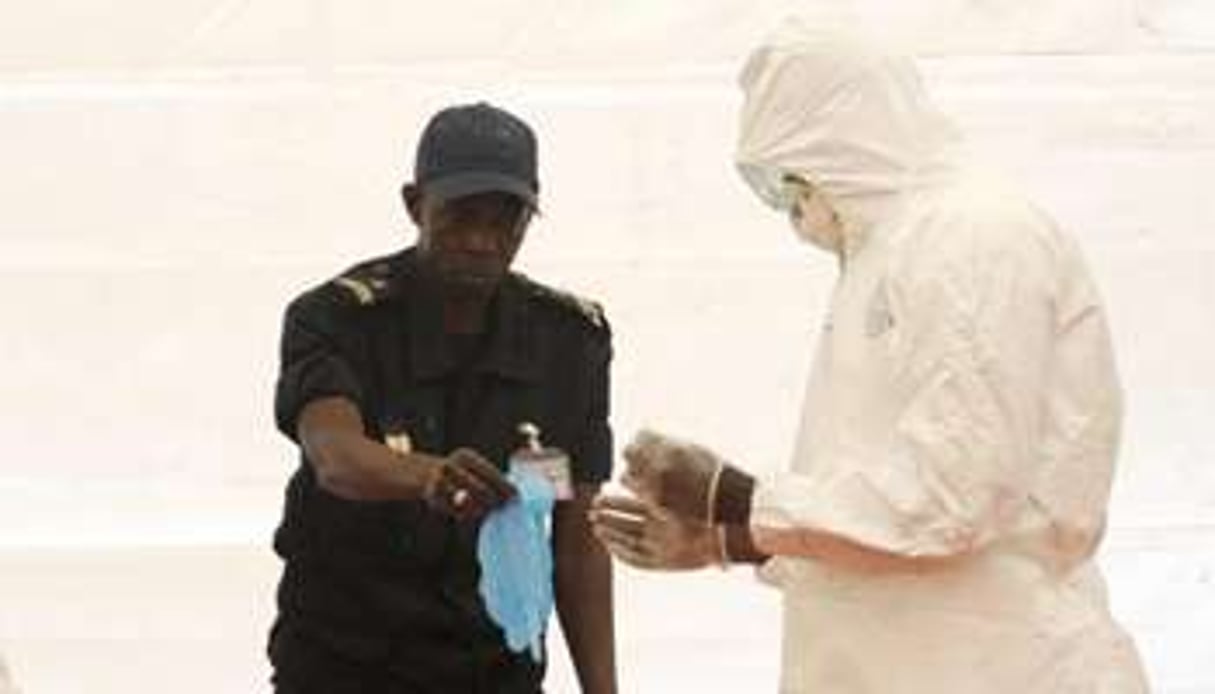 Un médecin sénégalais explique comment se protéger contre le virus Ebola à l’aéroport de Dakar © AFP