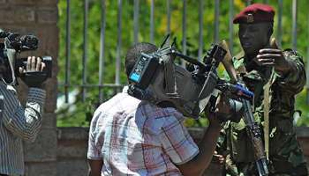 Un paramilitaire kényan demande à un journaliste de s’éloigner de l’entrée du stade Kasarani. © AFP